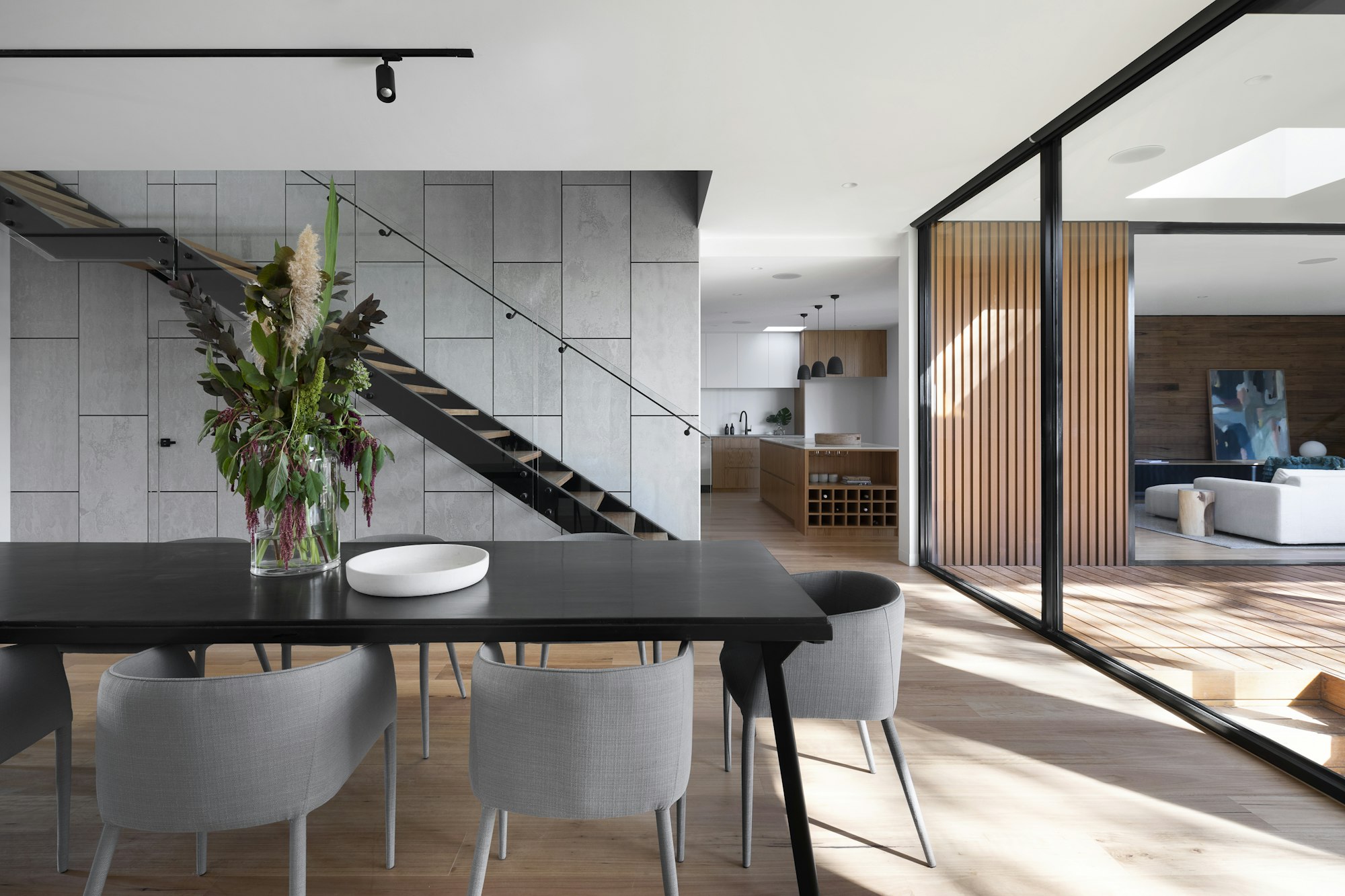 Composición arquitectónica contemporánea con hormigón visto, madera y vegetación natural